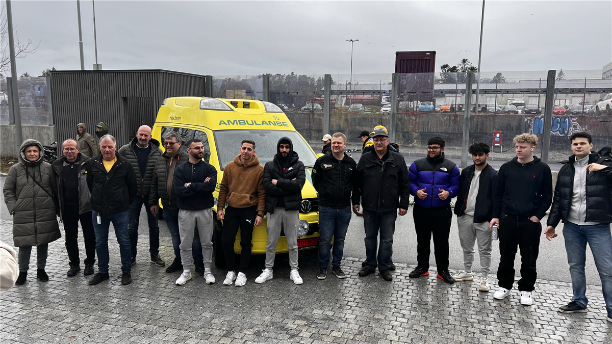 Personer stående forran ambulanse - Klikk for stort bilde